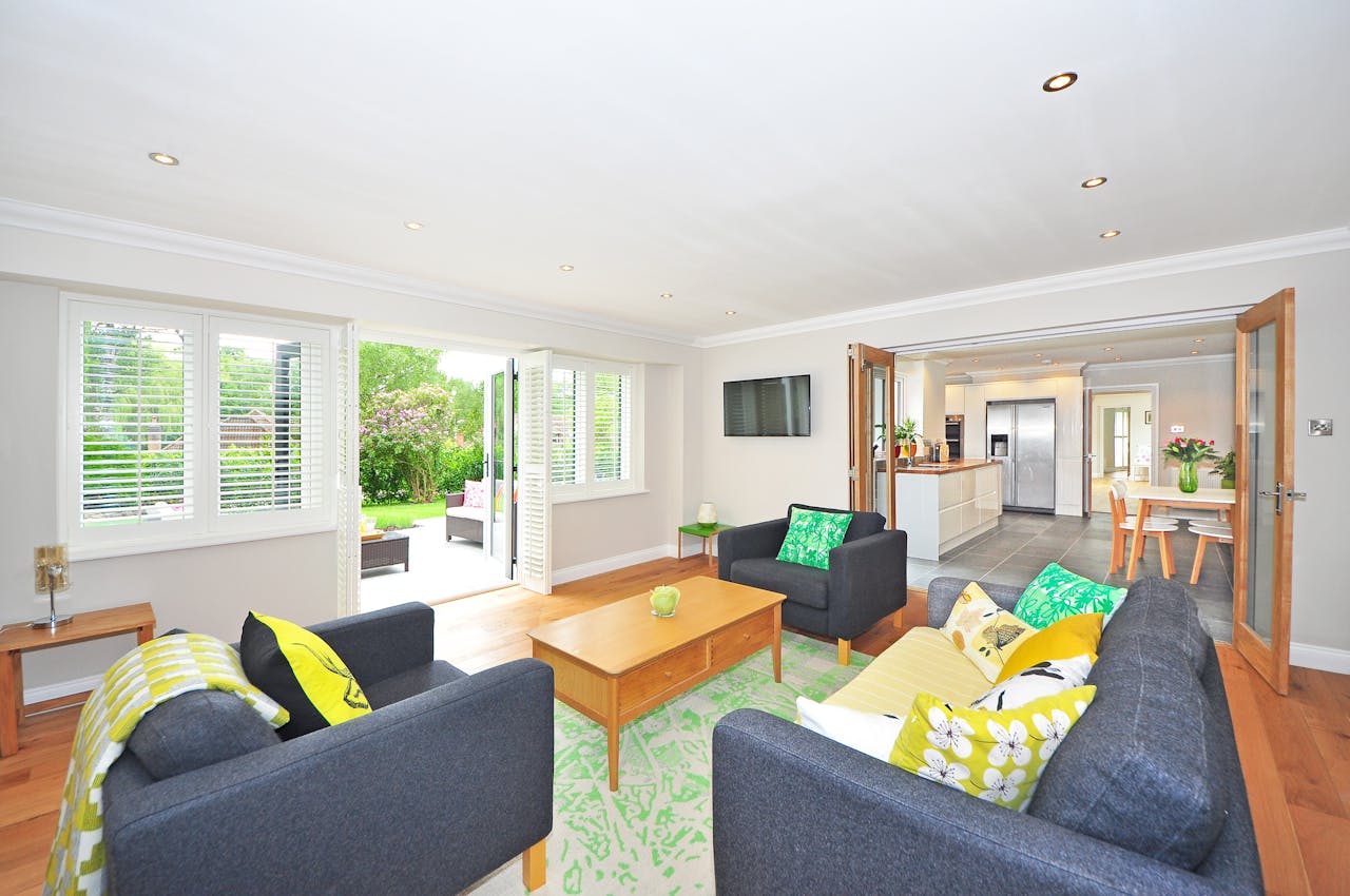 living room with green rug and open doors to kitchen