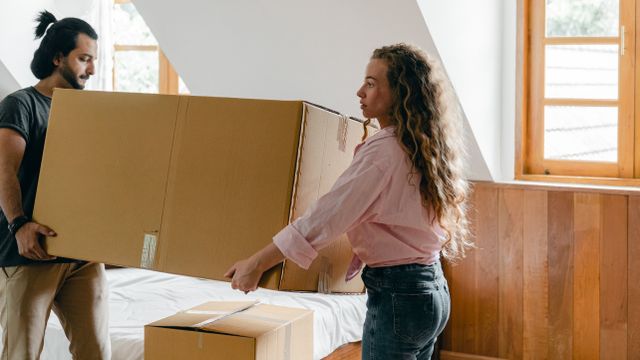 two people moving a large box